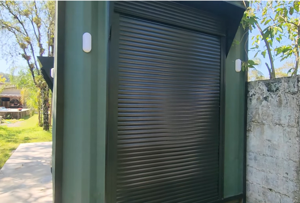 Detalhe da persiana de enrolar em alumínio preto na lateral do container