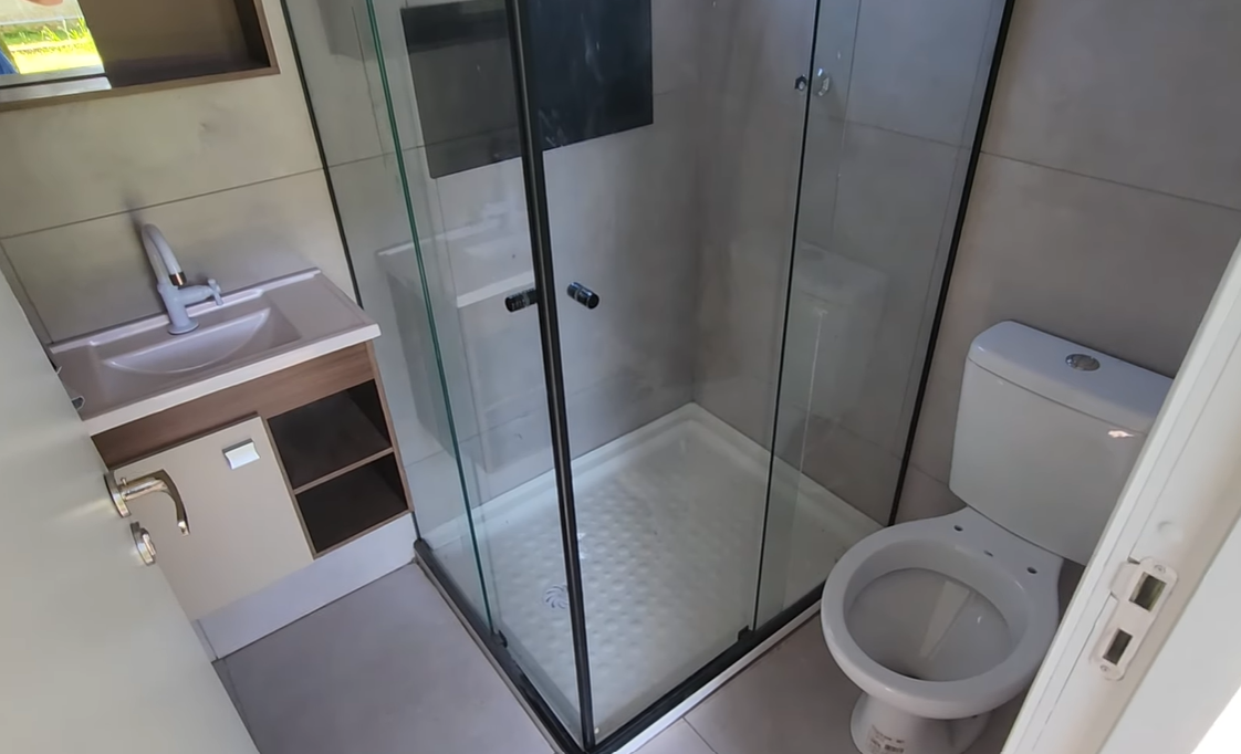 Banheiro completo com box de vidro temperado, bancada e vaso sanitário