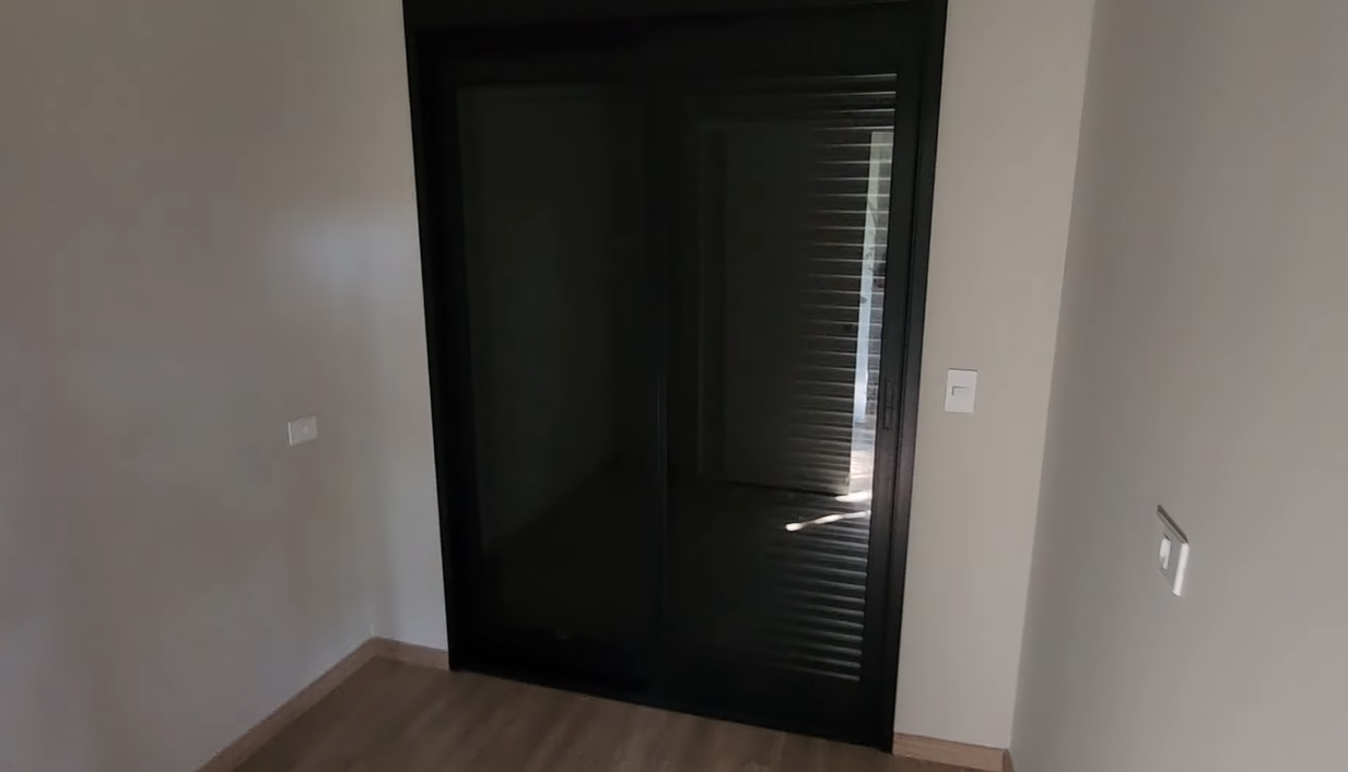 Dormitório com porta de correr em vidro e alumínio preto