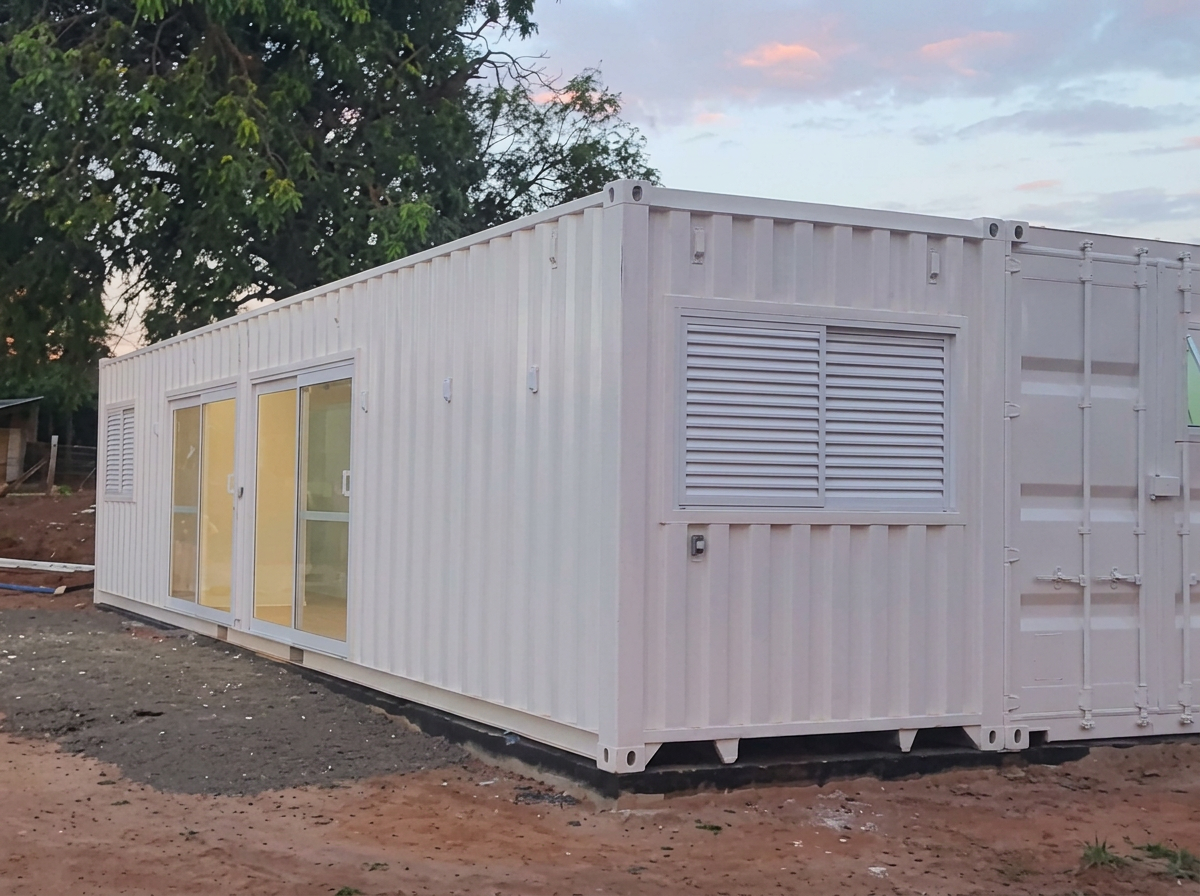 Vista lateral da casa container em terreno aberto