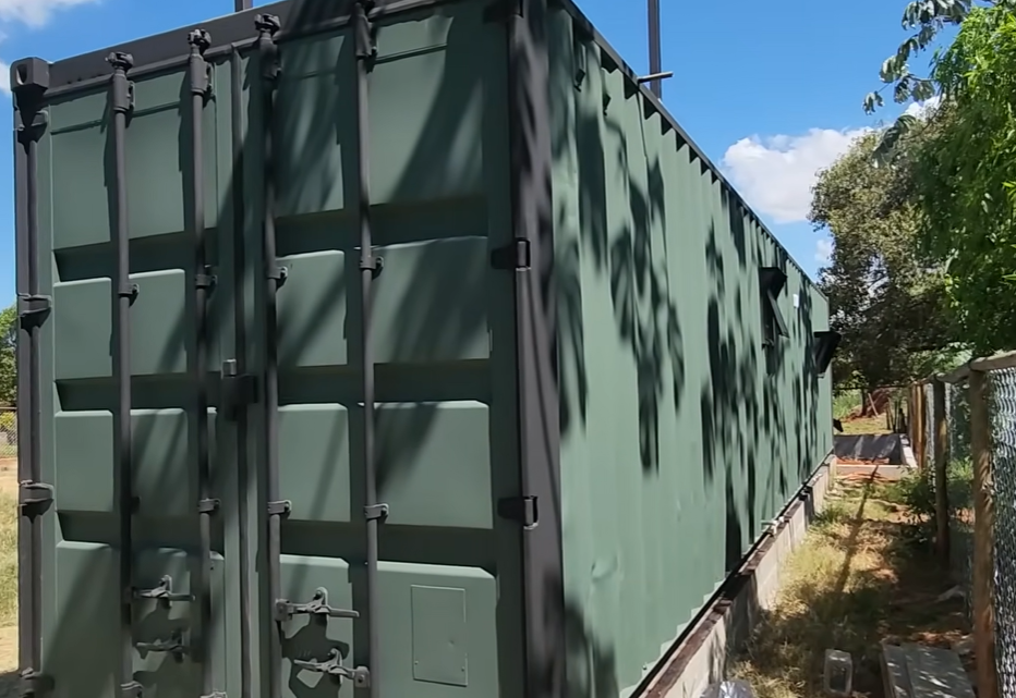 Vista lateral traseira do container em verde militar