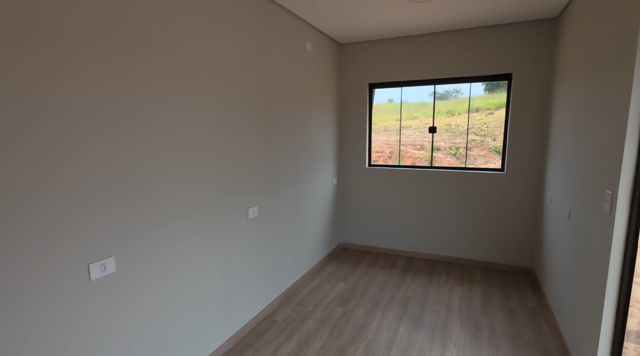 Ambiente interno com janela ampla e piso em madeira